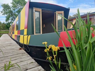 front of a narrowboat painted in bright dazzle camo