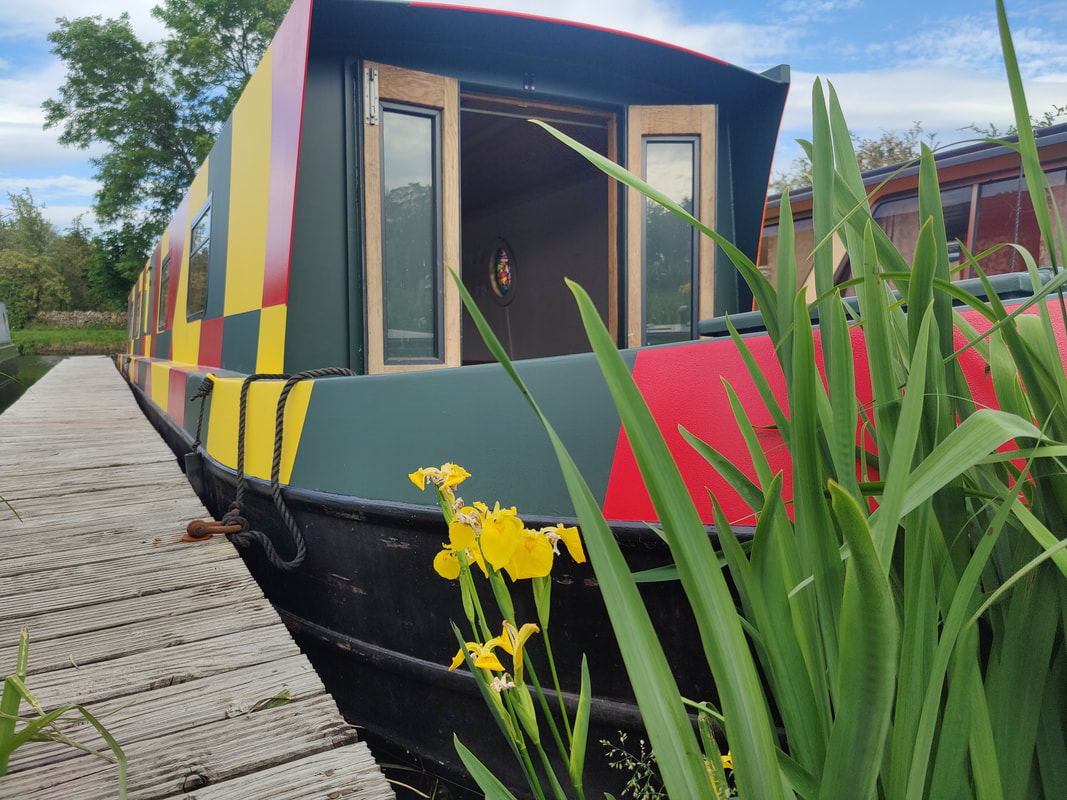 the front of a narrow boat painted in bright dazzle camo
